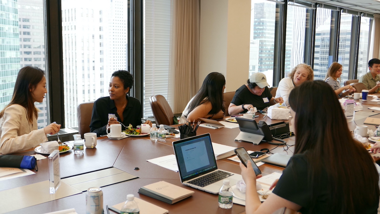 [Image description: Barnard entrepreneurs eating lunch around a conference table at Fried Frank in Midtown New York.]