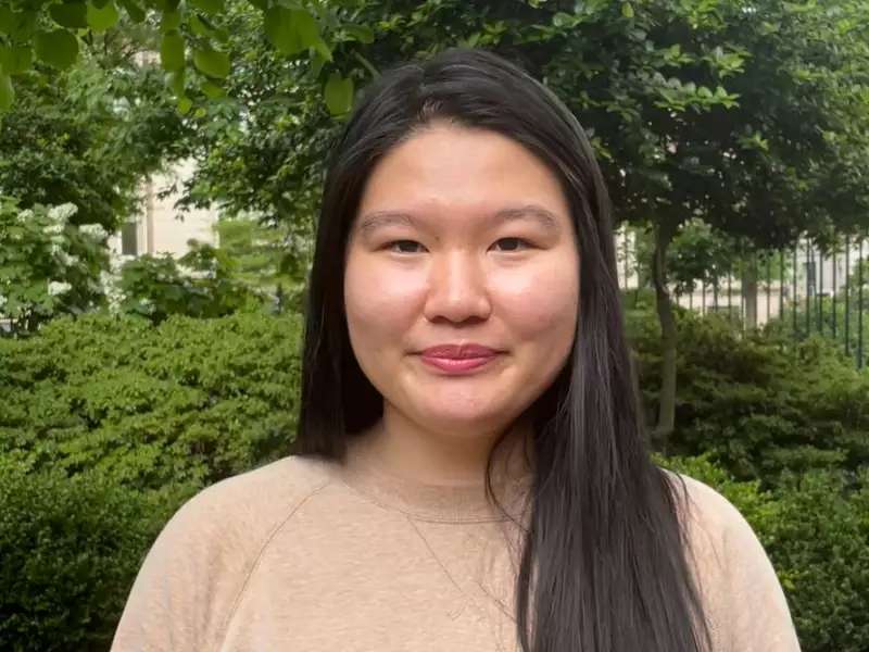 [Image description: Headshot of Jenny Chen outside in front of green foliage]